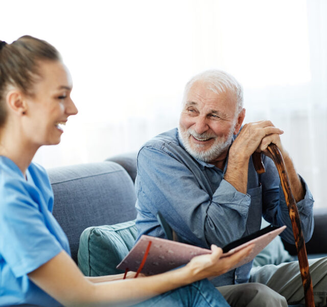 Nurse talking to smiling older man.